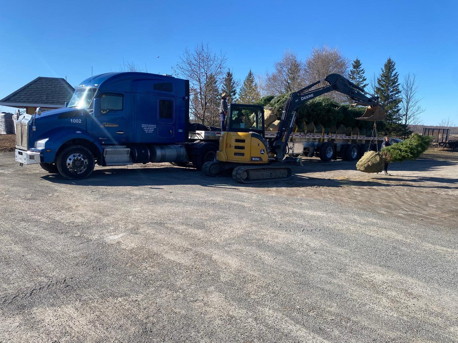 Novalight truck hauling an excavator